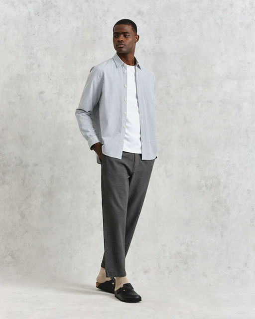 A man wearing Wax shelly shirt navy seersucker stripe