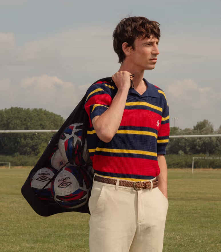 A man wearing a Umbro slacks and striped short-sleeve shirt