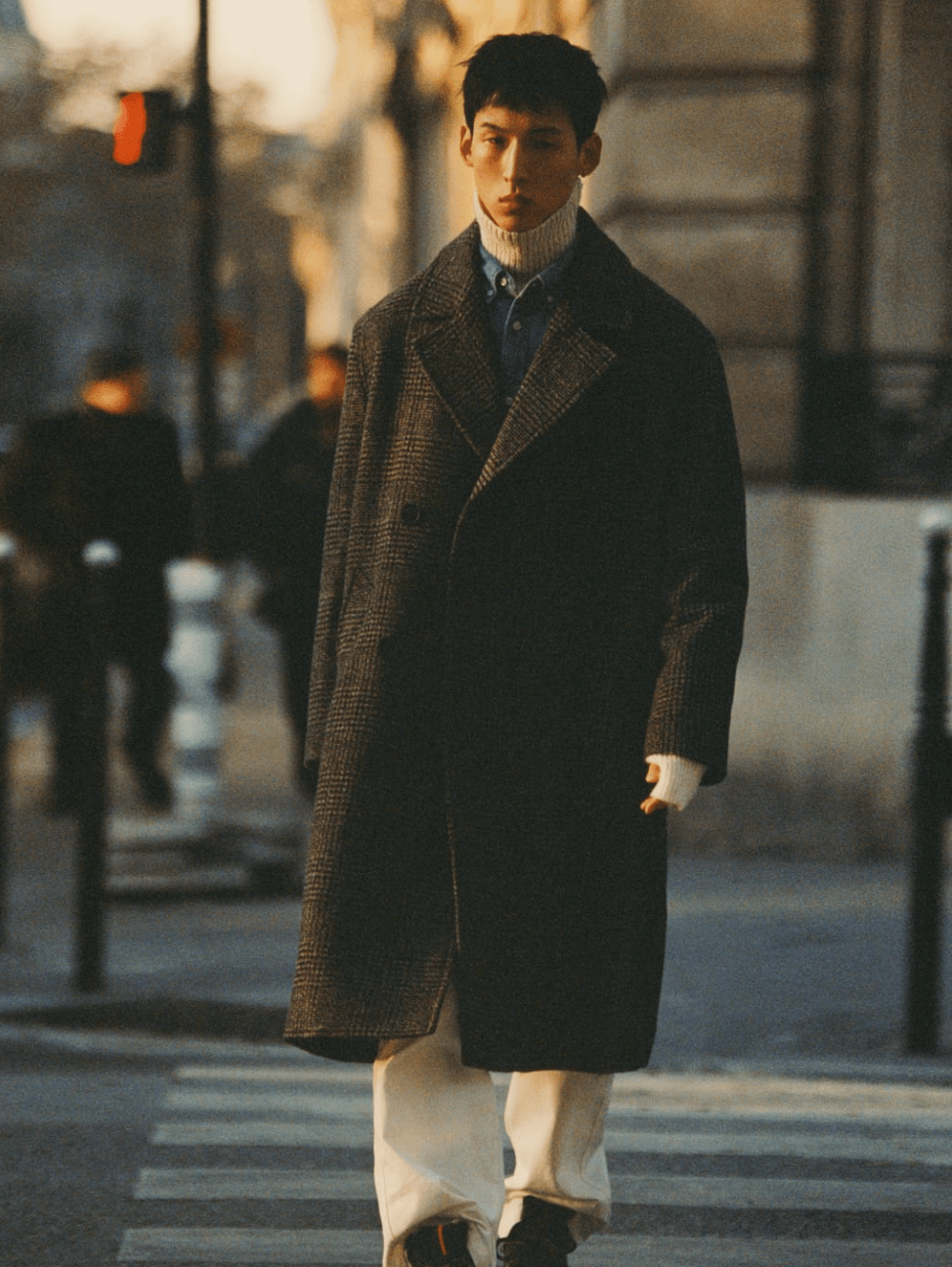 A man walking on the street wearing a Zara outfit featuring a brown jacket and beige turtleneck