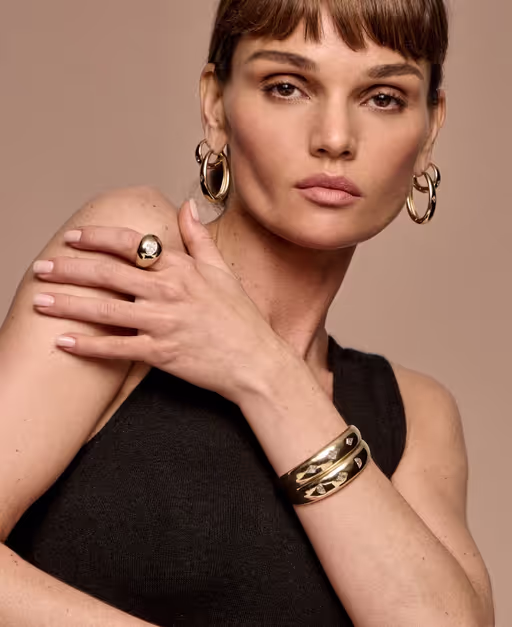 A woman wearing Vrai hoops earrings