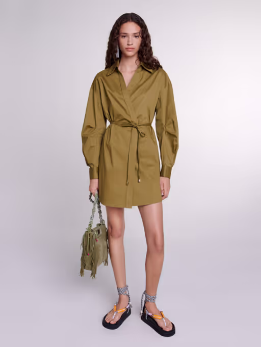 A woman wearing Maje khaki cutaway wrap dress