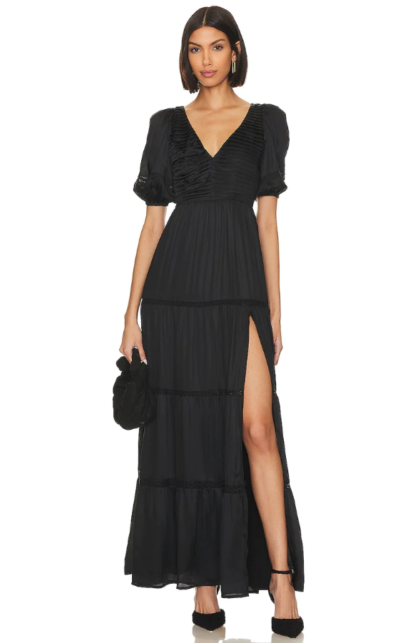 A woman wearing a black TULAROSA dress and heels