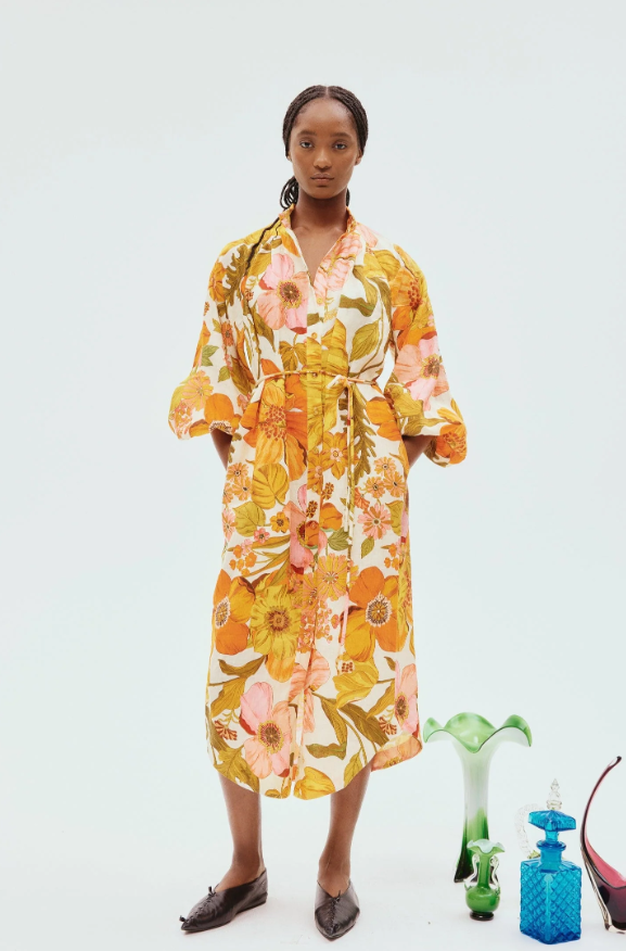 A woman wearing a yellow floral Alemais dress