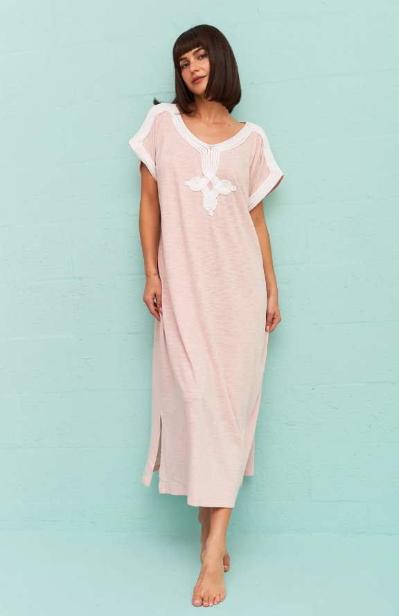 A wiman wearing a light pink Pitusa dress