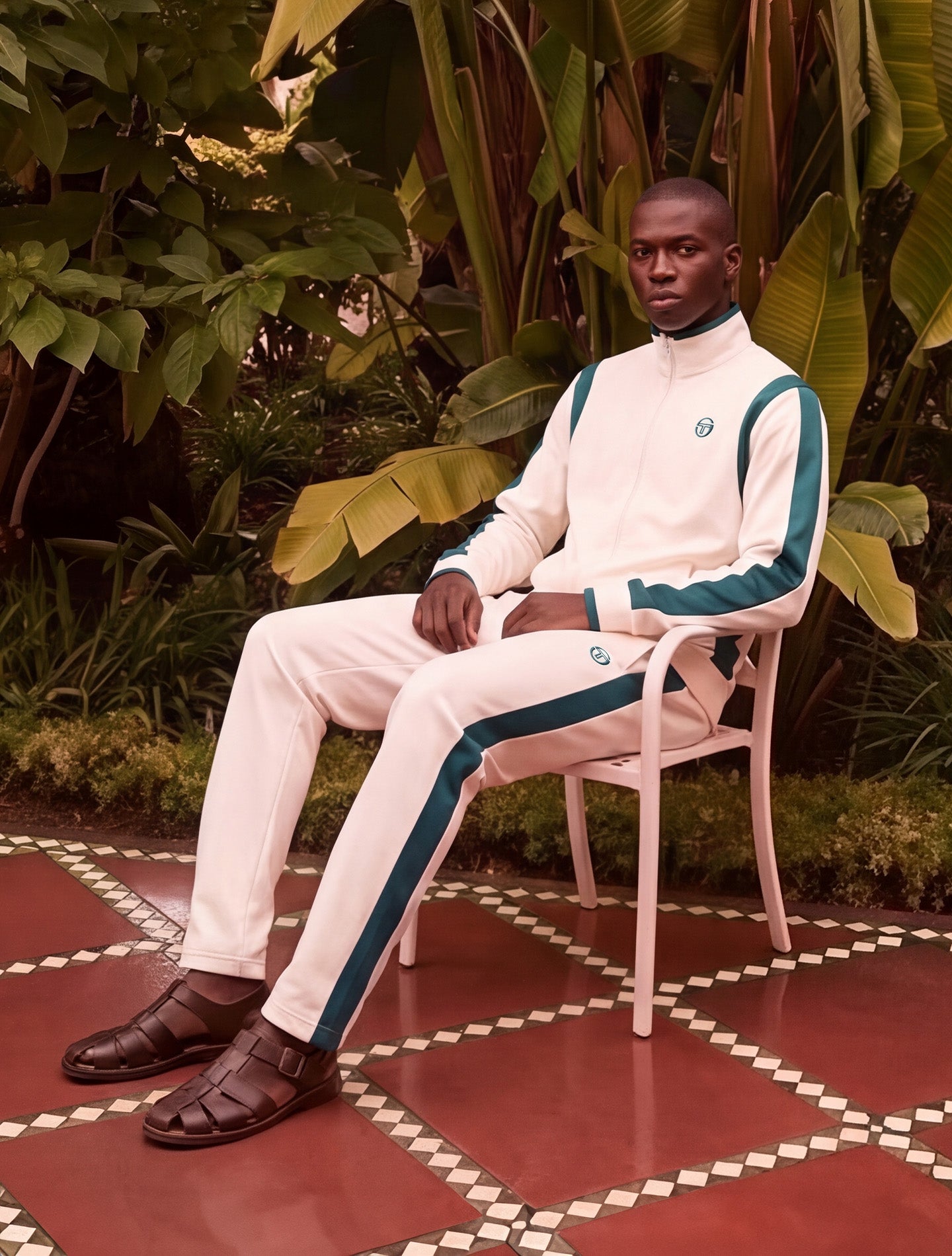 Sergio Tacchini model seated in a cream and green track suit
