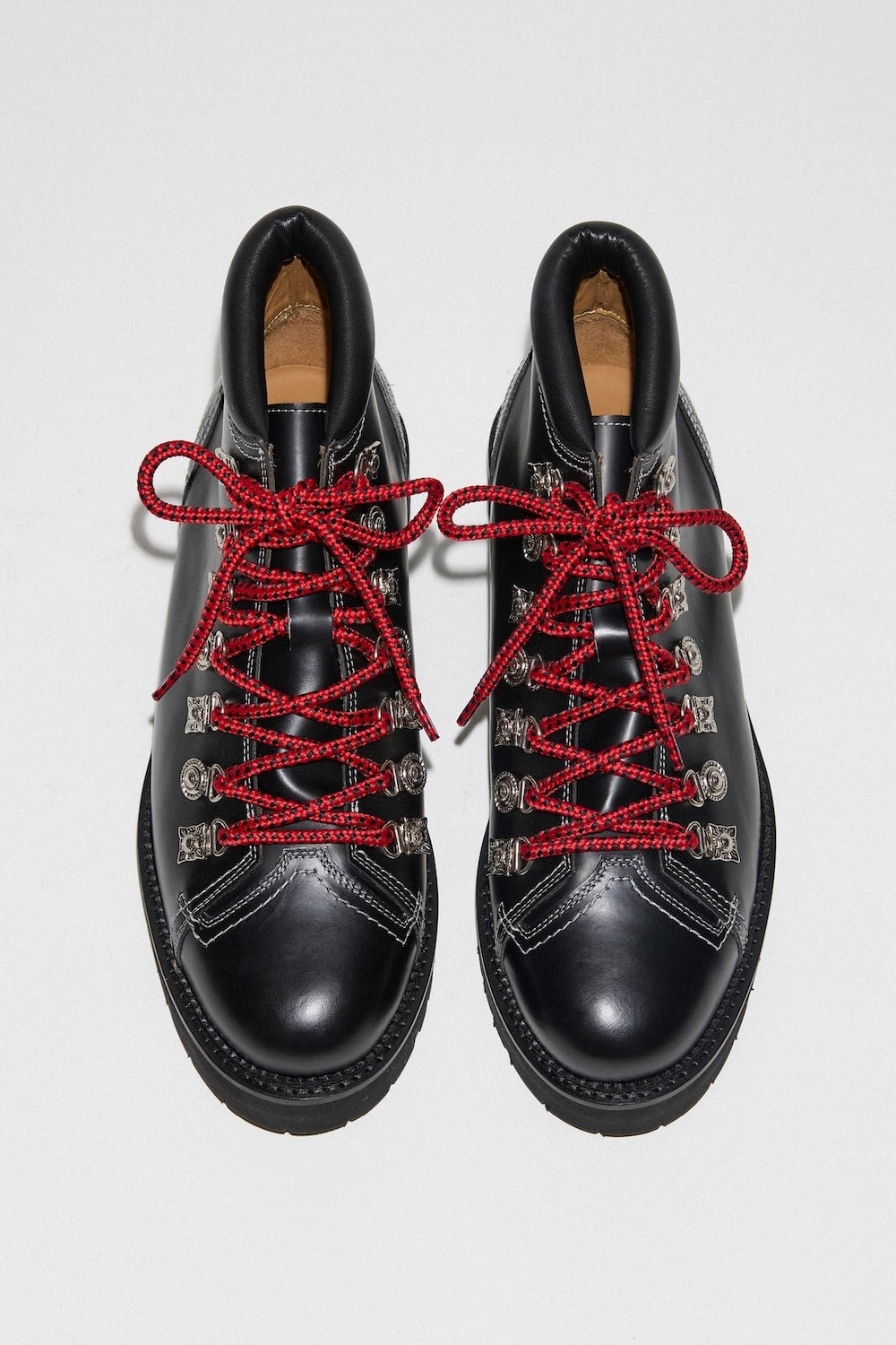 A pair of black leather Toga Virilis hiker boots with silver hardware and red laces