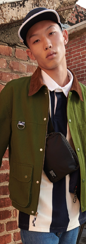 A man wearing a Levi's outfit featuring a green jacket and a white button up and jeans