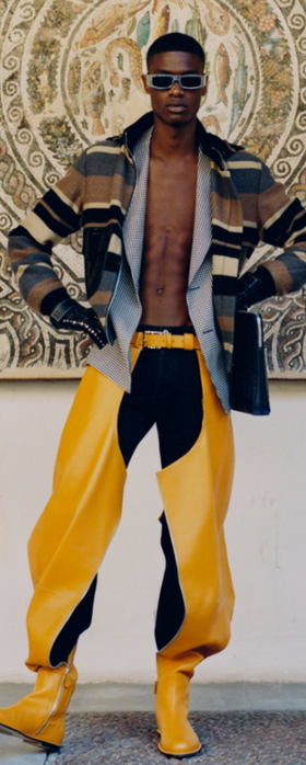 A man wearing a Loewe designer outfit with yellow pants and shoes and an open jacket