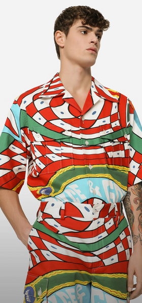 A man wearing a colorful Dolce & Gabanna button up with matching pants