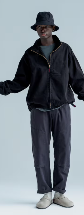 A man wearing a gramicci black fleece and a bucket hat